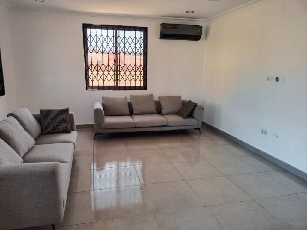 Clean living room with shiny tiled floor and sofas after a deep clean