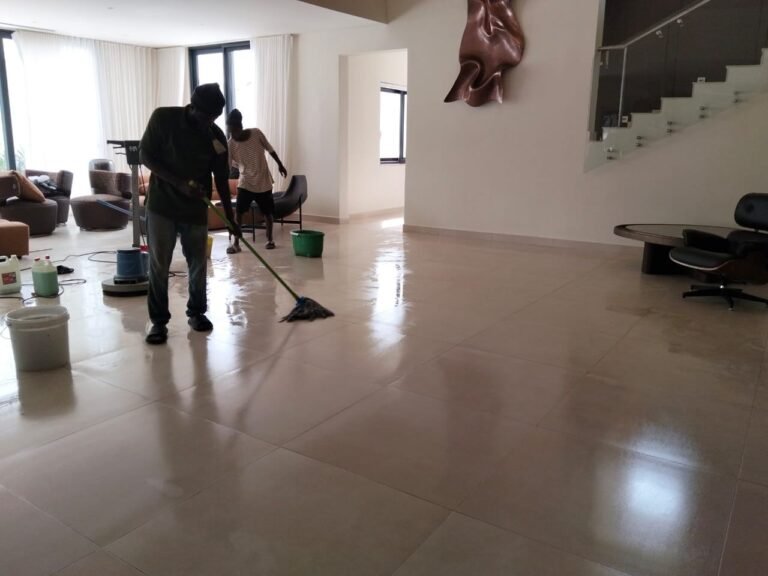 Compound being washed with a hose outside a bungalow in Accra