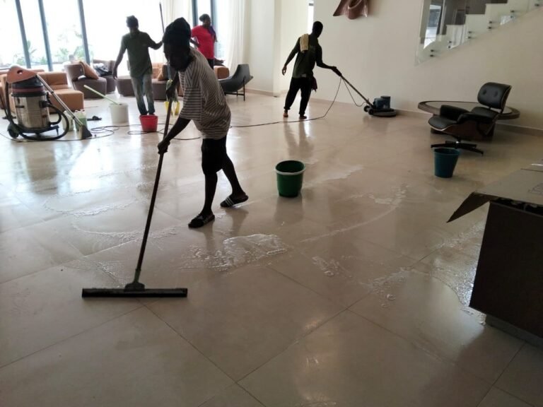 Dromo team squeegeeing and mopping a large tiled room during a deep clean
