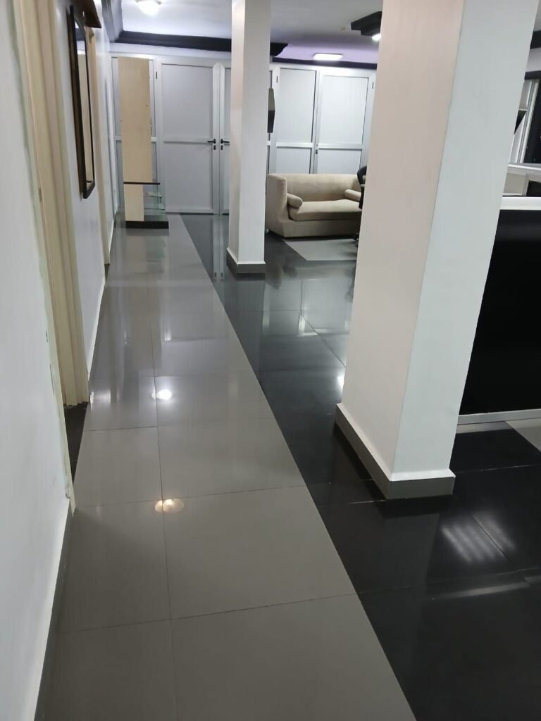 Office corridor with clean, polished black and white floor tiles