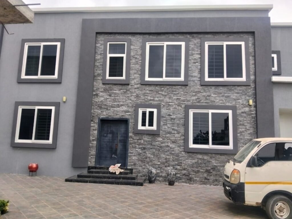 Front of a finished building with clean windows and stone cladding after post-construction cleaning